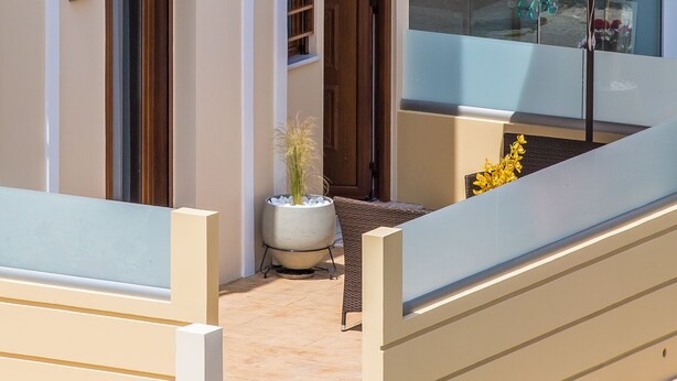 A modern building with a balcony, a door, and a potted plant. - Luxury Katsoulakis Apartments (Alikianos)