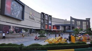 A shopping mall with a large outdoor area, a fountain, and a yellow inflatable structure. - Hotel Olive Saffron (New Delhi)