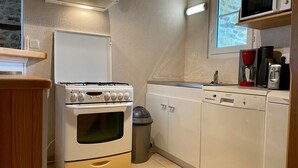 A compact kitchen with a stove, oven, microwave, and dishwasher.