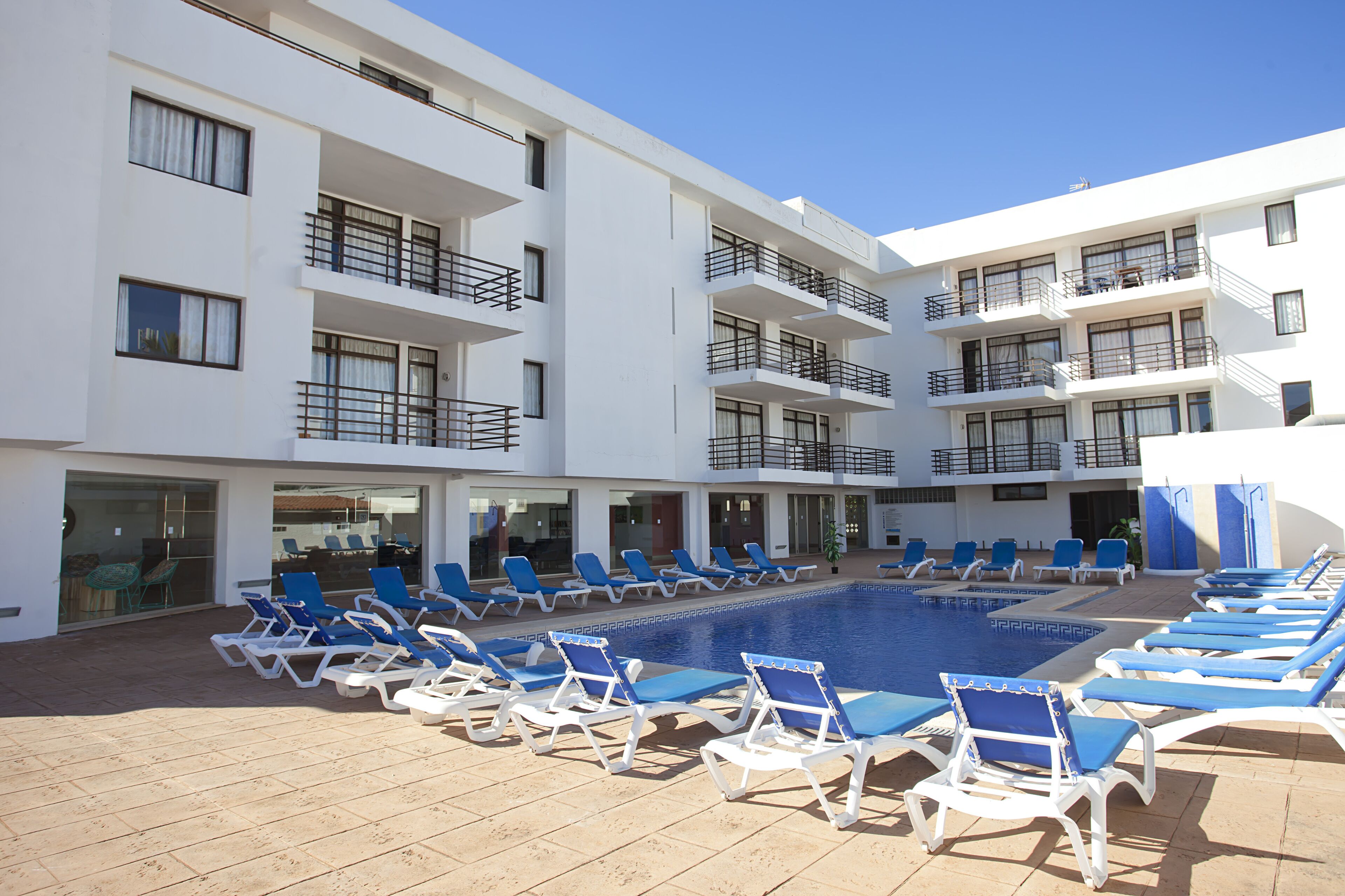 A poolside area with multiple lounge chairs and a swimming pool.