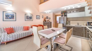 Un appartement moderne comprenant un coin repas, une cuisine et un salon.