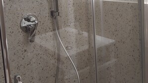 A shower with a glass door, a chrome showerhead, and a wall-mounted control panel. - Little paradise Suite in the center of Castel di Sangro (Castel di Sangro)
