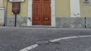 A building with a large wooden door, multiple windows with shutters, and a sign indicating a hospital nearby. - Little paradise Suite in the center of Castel di Sangro (Castel di Sangro)
