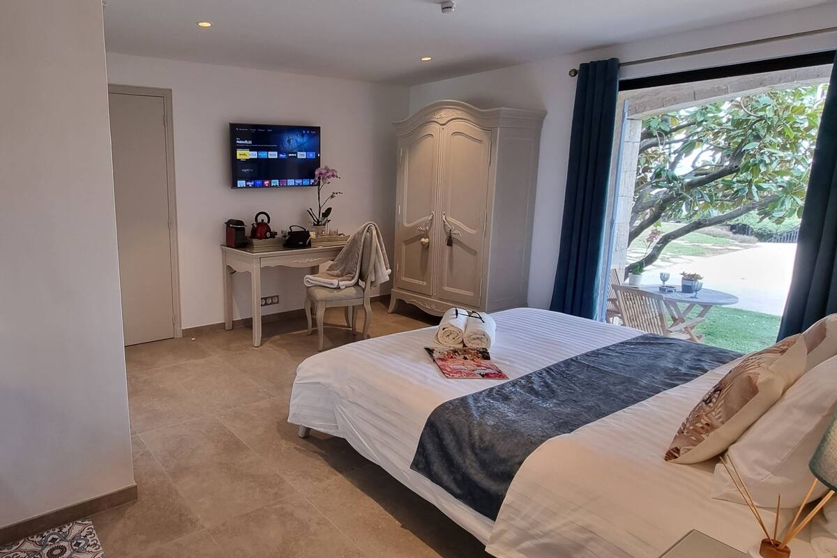 Habitación de hotel con cama, escritorio, televisor y armario.