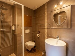 Une salle de bain avec une douche, des toilettes et un lavabo.