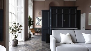 Un salon moderne avec un canapé gris, un meuble noir et une plante en pot.