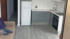 A modern kitchen with white cabinets, a built-in oven, and a sink.