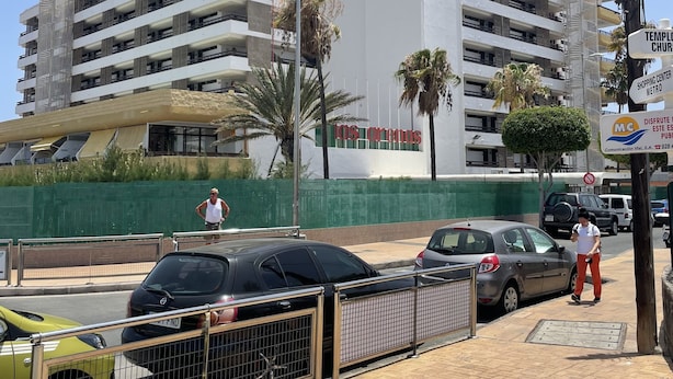 A multi-story building with balconies and a sign that reads "Los Orreos."