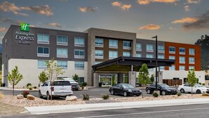 A Holiday Inn Express & Suites building with a modern design, featuring multiple floors, a covered entrance, and a parking area with several cars. - Holiday Inn Express & Suites Nephi by IHG (Nephi)