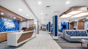 A modern hotel lobby with a reception desk, seating area, and a long corridor. - Holiday Inn Express & Suites Nephi by IHG (Nephi)