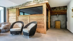 A room with a wooden wall, two wicker chairs, a fireplace, and a large window. - Holiday Apartment "Weiße Zinne" with Shared Whirlpool & Garden (Valle Aurina)