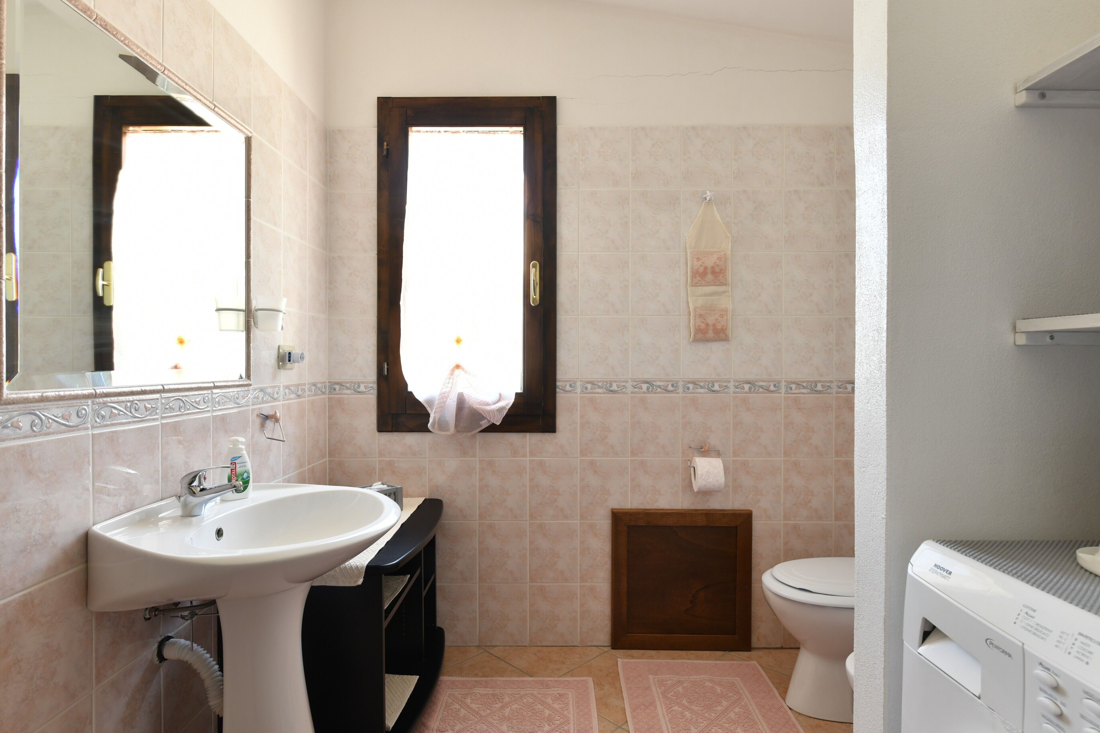 Ein Badezimmer mit Waschbecken, Toilette und Fenster.