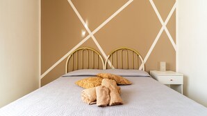A neatly made bed with a headboard, pillows, and folded towels. - Holiday Apartment Amare 1 close to the Beach with Covered Terrace & Garden (Torre Specchia Ruggeri)