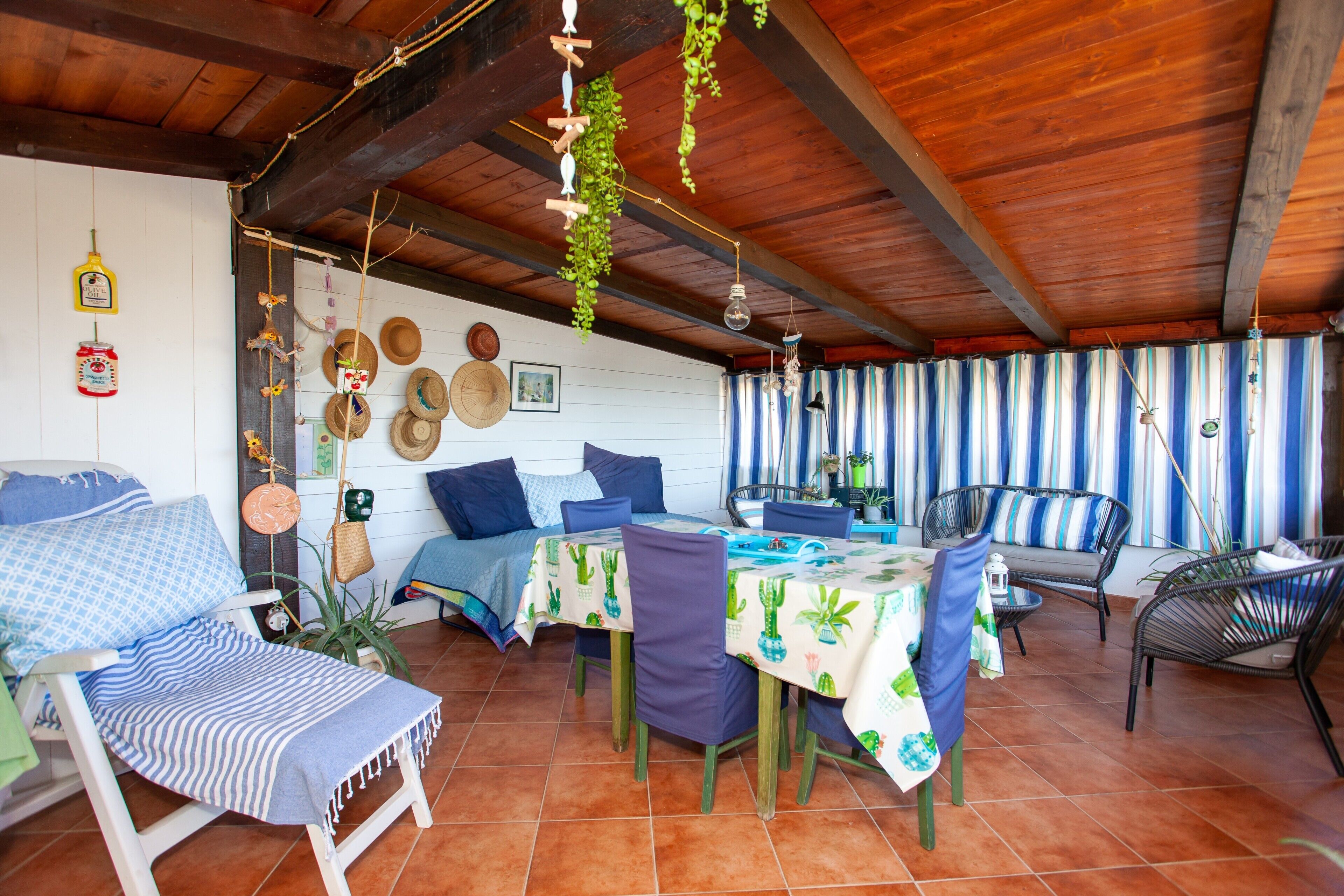 A cozy patio area with a dining table, chairs, and a sofa.