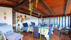 Un patio acogedor con una mesa, sillas y un sofá.