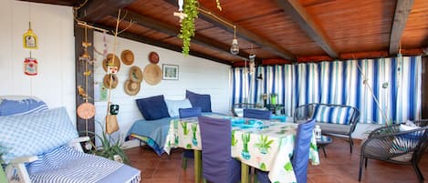Un patio acogedor con una mesa, sillas y un sofá.