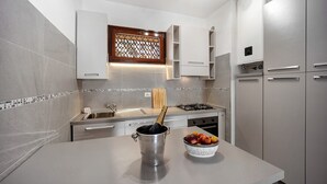 Una cocina moderna con un lavamanos de acero inoxidable, un cubero para vino y un cuenco de fruta.