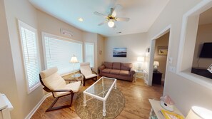 Relax in this stylish living room with a sofa, armchair, and flat-screen TV.