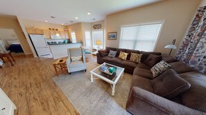 Relax in a cozy living space with a comfortable sofa, armchair, and modern kitchen.
