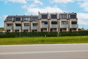 A modern multi-story residential building with balconies and a brick facade.