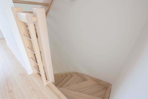A wooden staircase with a handrail and a wooden floor.