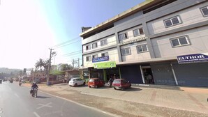 A street view with a building housing a medical center, a reception area, and a closed shop. - Hotel Keerthana Inn (Puttur)