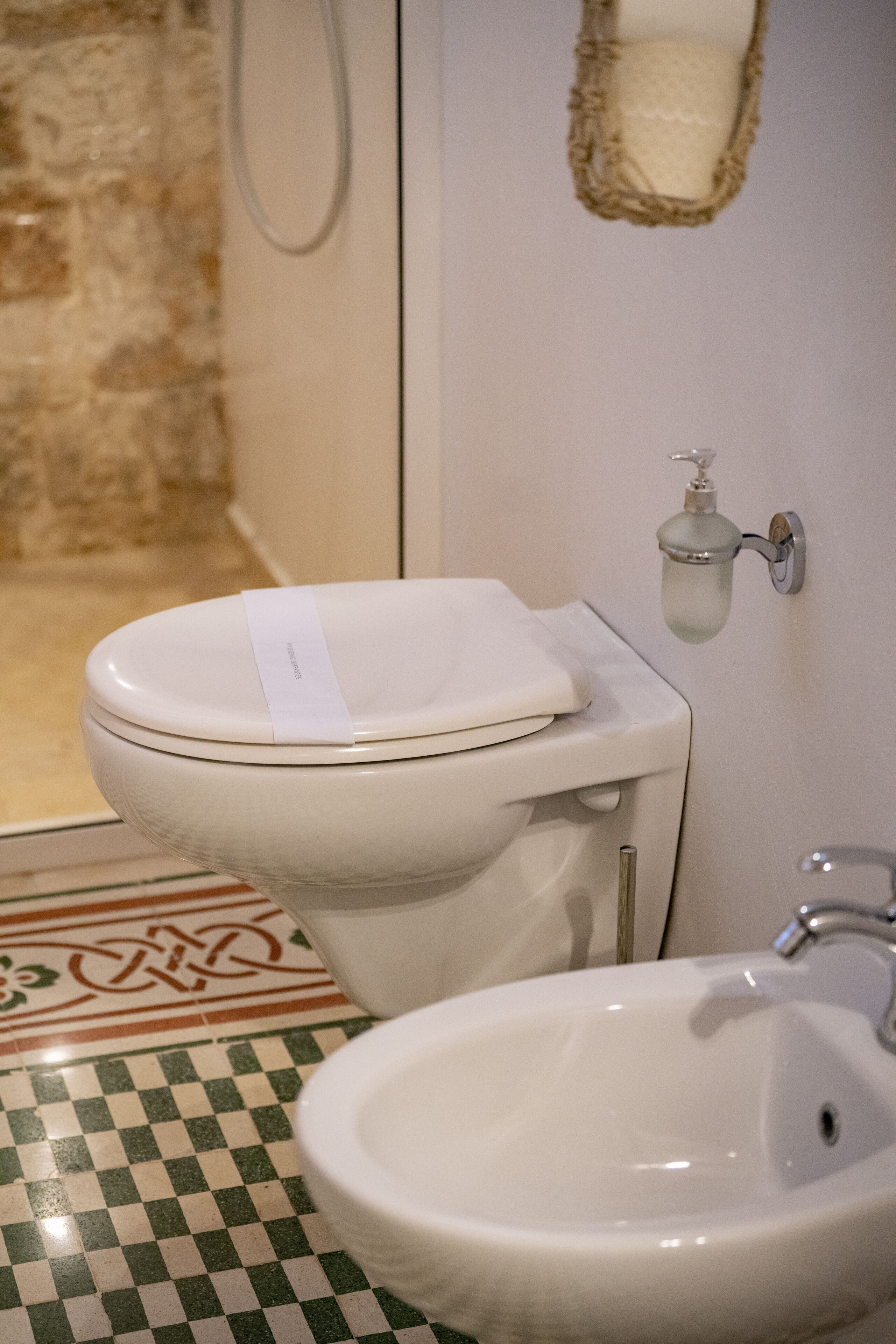 Une salle de bain équipée de toilettes, d’un bidet et d’un lavabo.