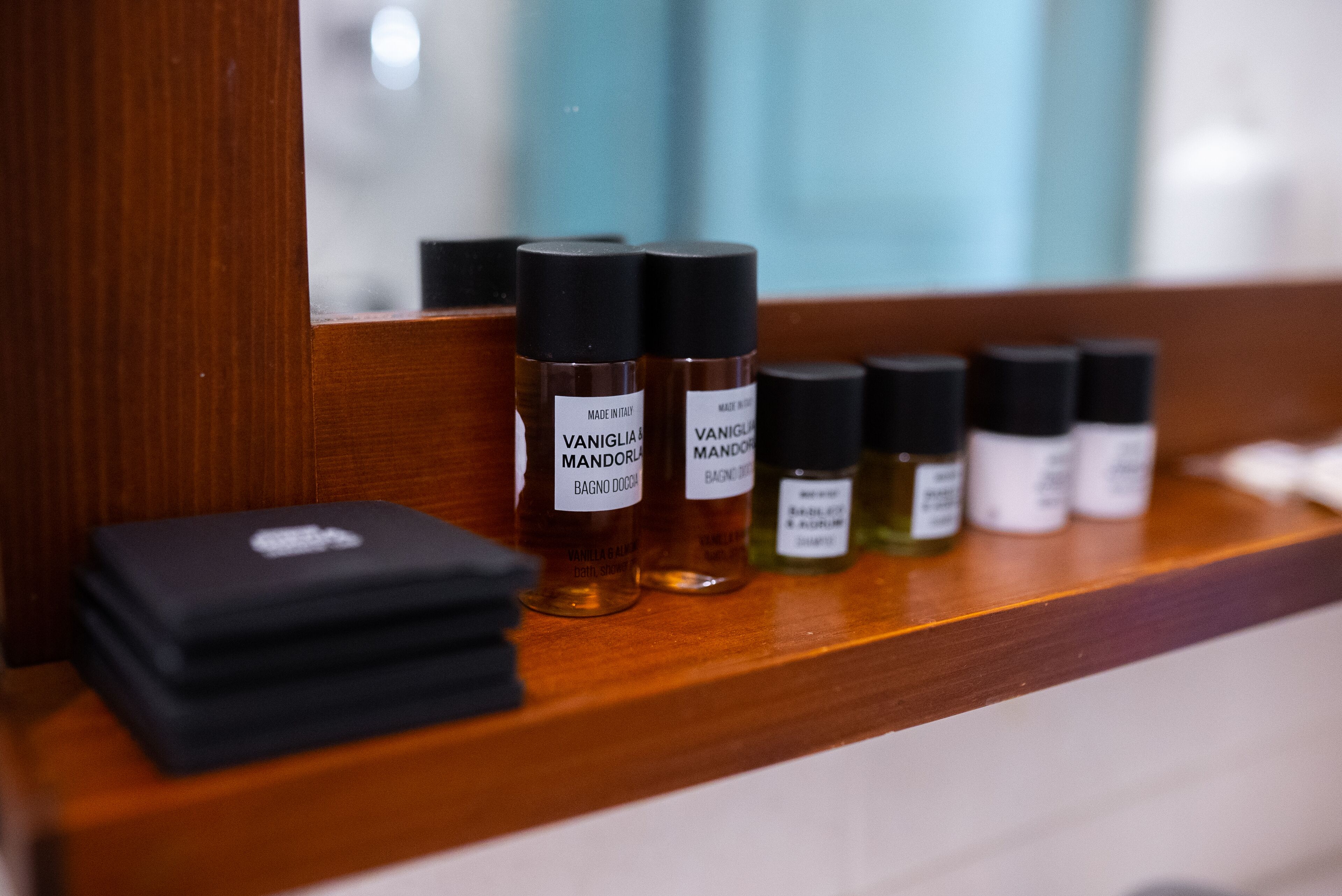 Een houten plank met verschillende flessen vanille-geparfumeerde bodyspray.