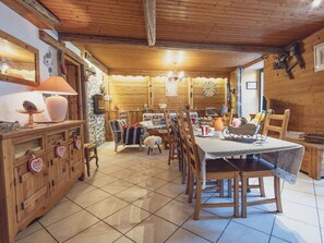 A cozy dining area with wooden furniture, a chandelier, and a rustic interior.