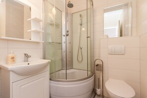 A modern bathroom with a glass-enclosed shower, a white sink, and a toilet. - Relax in this modern flat in Baska on Krk (Baska)