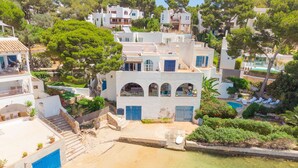 Zona residencial costera con edificios blancos, una piscina y una vista despejada del mar.