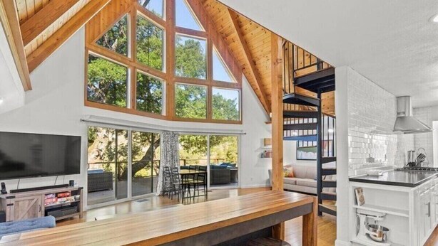 A modern kitchen with a wooden bar, large windows, and a view of the outdoors. - Alexander Valley Russian River Home for 8, Spa, WiFi, BBQ, bocce, vineyard (Cloverdale)
