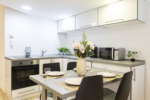 Design appartement | Privékeuken | Een koelkast met diepvriezer, een microgolfoven, een oven, een kookplaat