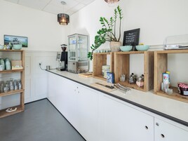 Una cocina moderna con estantes de madera, una cafetera y diversos utensilios de cocina.