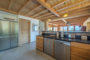 Una cocina moderna con vigas de madera, electrodomésticos de acero inoxidable y una isla grande.