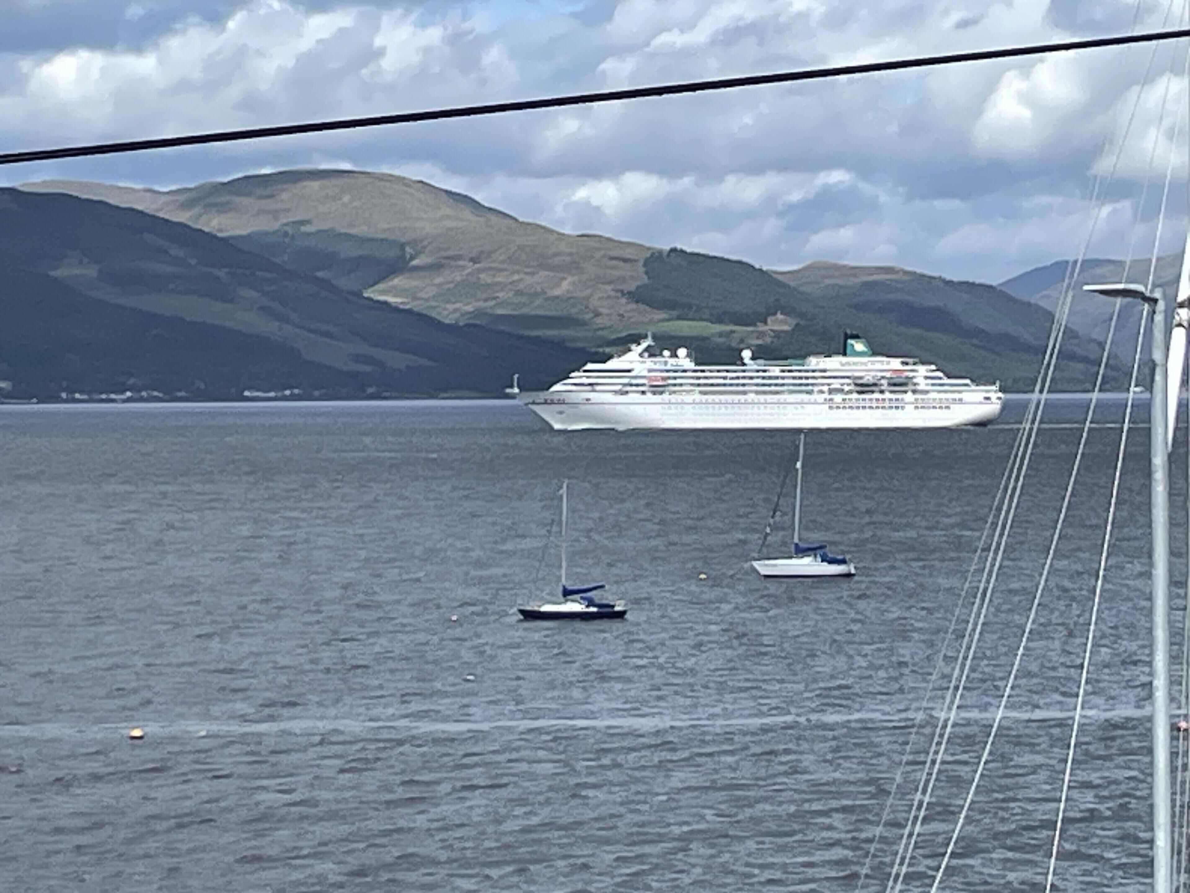 A cruise ship in a body of water with mountains in the background.