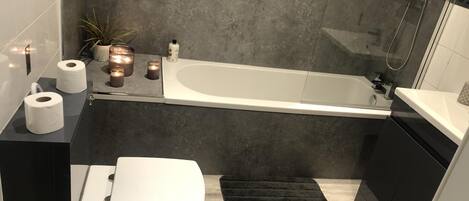 Ein modernes Badezimmer mit Badewanne, Toilette und Waschbecken.