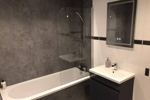 Kombinert dusj/badekar, dype avslapningsbadekar, hårføner og håndklær