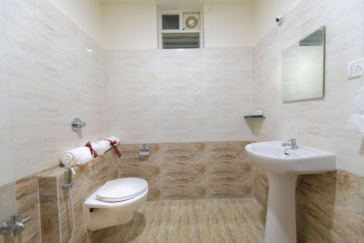 Uma casa de banho com sanita, lavatório e chuveiro.
