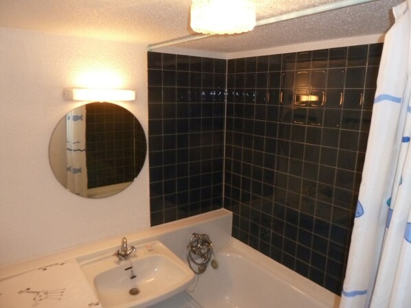 A bathroom with a white sink, a mirror, and a bathtub. - South-facing studio for 2 with balcony - Valloire (Valloire)