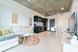 Un espace de vie moderne comprenant un canapé, une table basse et un coin repas.