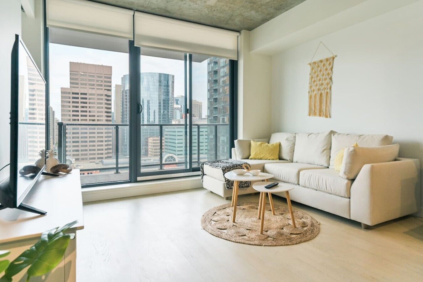 A modern living room with a sofa, a coffee table, and a TV on a stand.