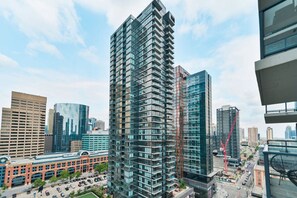 Un immeuble de grande hauteur au design moderne, entouré d’autres bâtiments imposants dans un environnement urbain.