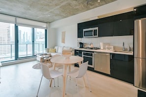Uma cozinha moderna com área de jantar, grandes janelas e vista para a cidade.