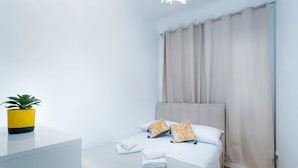 A hotel room with a bed, a bedside table with a potted plant, and a curtain. - Apartment Jany (Dubrovnik)