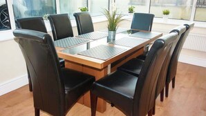 Een vergaderzaal met een glazen tafel, zwarte leren stoelen, een potplant en grote ramen.