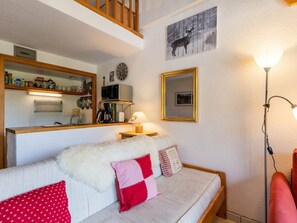 Ein gemütliches Wohnzimmer mit einer Couch, einer Kaffeemaschine, einer Mikrowelle und einem Kamin.