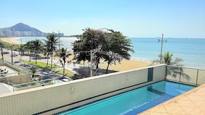 Una piscina con vistas a la playa y al océano.