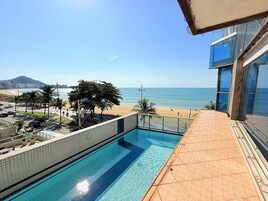 Una piscina con vista a la playa y al océano.