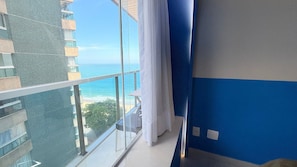 A balcony with a view of the ocean and a building with a mesh facade. - Diamond Beach (Vila Velha)
